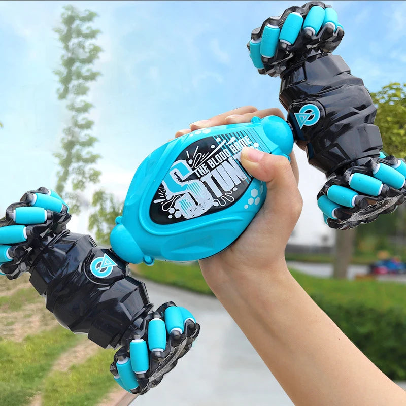 Blue and black device with claw-like ends held by a hand outdoors.